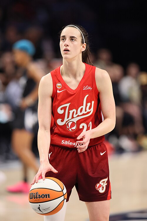 Caitlin Clark holding a basketball in an Indiana Fever uniform in 2026. Player photograph, not card artwork.