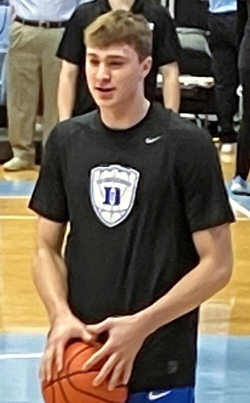 Cooper Flagg holding a basketball during Duke warmups in March 2025. Player photograph, not card artwork.