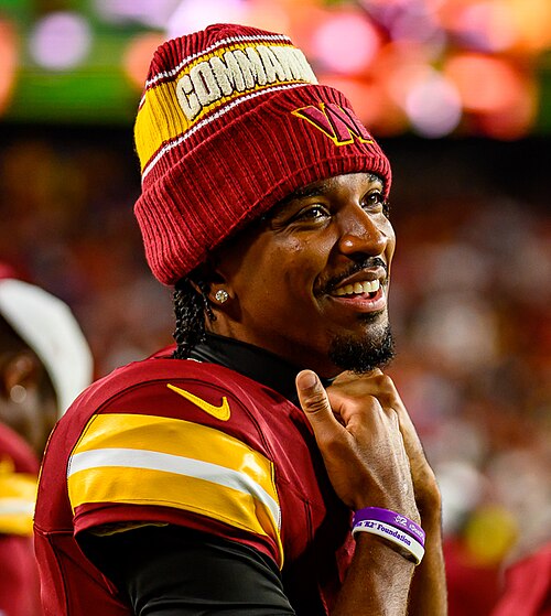 Jayden Daniels in a Washington Commanders uniform and knit cap in 2025. Player photograph, not card artwork.